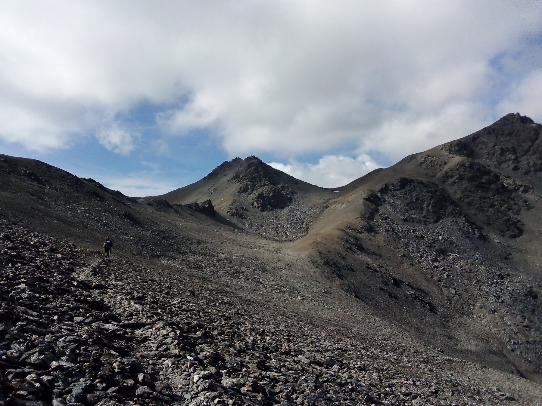 In fondo, subito sopra la piccola chiazza di neve, il colle Rasis Ovest dal sentiero che arriva dal colle di Thures. A destra la punta Rasis.