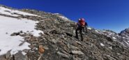 traversando il ripido pendio di pietrame che porta sul crestone SO del Roc del Boucher