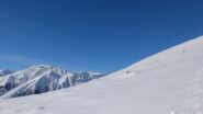 Il profilo del pendio finale e dietro le belle cime dell'alto lario