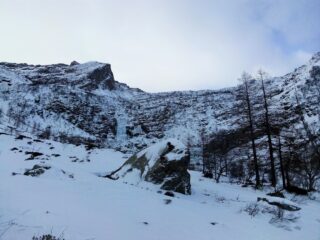 Al piano del Trione. Al centro la cascata ghiacciata. L'itinerario risale il pendio nevoso di sx, molto vicino alla bastionata, per poi curvare a dx sopra di essa, in costa.