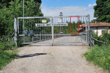 L’ingresso del sentiero nel Bosco del Mezzanone, blindato dal cancello telecomandato. Pedone e bicicletta passano – con fatica - nello spioncino