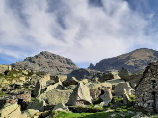 Alpe di Lee. Sullo sfondo, a destra, l'inconfondibile torrione del Colle di Nora.