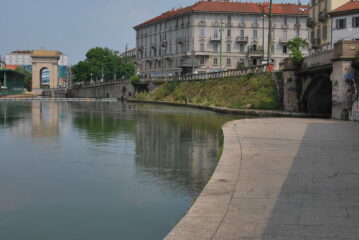 Overview della Darsena: l’arrivo del Naviglio Grande (primo piano), la partenza del Naviglio Pavese e l’arco di Porta Ticinese sullo sfondo