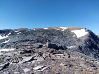 Il crestone verso il Giusalet (del quale si intravede, a sinistra, la croce di vetta) dalla cima di Bard. La segnaletica guida attraverso la zona di roccioni grigi.
