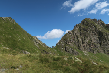 Il colle visto da sopra il Lago Santanel. Appena intuibile la traccia nell'erba che abbiamo percorso, che taglia il versante in piano per portarsi sopra il lago