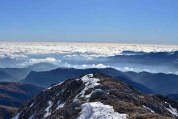 Dalla cima sguardo verso il mare di nuvole e la Corsica in lontananza