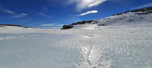 lago ghiacciato e parzialmente innevato