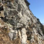 A sin.  sotto il roccione nero, la partenza della via.   A dx la partenza di 