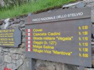 Tabella sentieri in prossimità della chiesa di Peio.