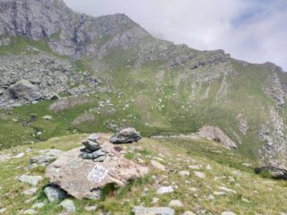 Il masso con la scritta sull'orlo di Pian Sulè: la traccia risale i pendii in centro foto.