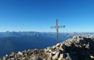 Croce di vetta Roc Peyrous e Monviso in lontananza sulla sinistra