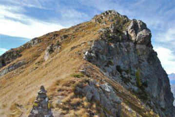 Al Colle Sella: l’ometto e la Punta Sella. La via di salita alla punta è sull’erba lungo la cresta.