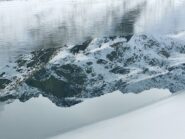 Riflessi su una porzione del lago blu non ancora ghiacciata