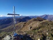 Croce di vetta e sguardo sulle Alpi Liguri