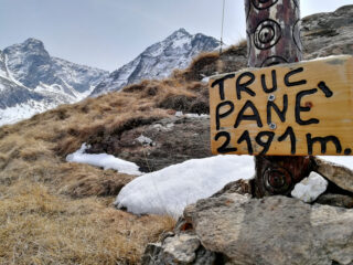 Cima con diario di vetta e palo di legno decorato.