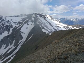 Dall'antecima si vede il crestone percorso, il nevaietto del colle delle Moure e i rimasugli di neve sul sentiero per il colle
