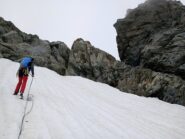 Calata su chiodo e spuntone uniti da cordino giallo e rosso, da accesso al nevaio/ghiacciaio e poi con una discesa faccia a monte si arriva alla pietraia e di lì alla normale.