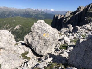 Il masso col bollo giallo. Sullo sfondo la Corna Rossa