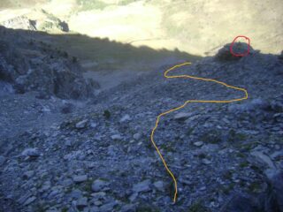 Dorlier: la traccia in traverso svanisce, risalire su sfasciumi; cerchiato l'ometto di riferimento che riporta sulla traccia più in alto.