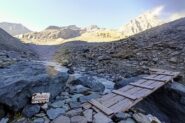 La passerella prima della lunga pietraia e l'ultima indicazione (d'epoca) per la vetta (quota 2650m)