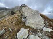 Sulla cresta, roccione con resti della segnaletica. il sentiero più evidente, scende a sinistra al colletto per innestarsi sulla via normale. Aggirare il roccione a destra e proseguire dritti sulla cresta...