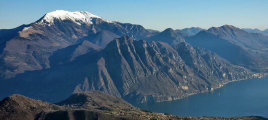 Corna Trentapassi in primo piano sul Lagao d'Iseo. Alle spalle innevato Punta Caravina