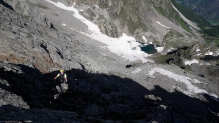 in cresta con in basso al centro il lago d'arpisson in parte ancora ghiacciato..