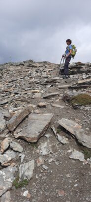 arriva in vetta su pendio finale pietroso