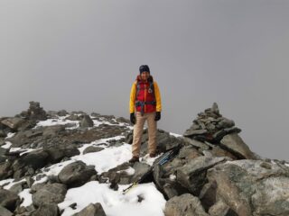 All'ometto di vetta con nebbie e vento freddo