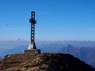 La croce di vetta con in lontananza Monte Rosa e Mischabel.