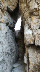 Buco nella roccia dove si accede alla cengia con corrimano finale