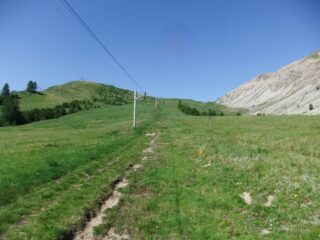 Salita per prati sotto al sole verso la dorsale