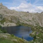 Il Lago Vercoche salendo al Col Laris, con il ricovero e lo sbarramento sull'emissario, che va attraversato per imboccare il sentiero