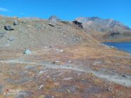 Il punto, segnalato da un ometto con freccia gialla, in cui si lascia la riva ovest del lago Rosset per salire a sinistra.