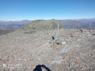 il cippo di vetta visto dal punto panoramico verso valle