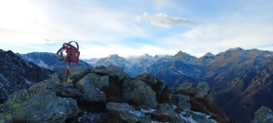 Il segnale di vetta di punta Sourela, con dietro le cime della val di Viù