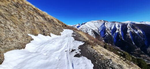 Strada per la colla Bassa innevata in mezzo ai prati spogli