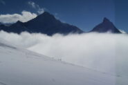 Grivola e Grand Nomenon con alcuni scialpinisti in discesa verso la nebbia