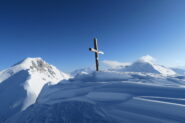 la croce della cima, a sinistra il Monte Rosso, a destra il Fallere
