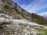Vista della frana (detriti marroni nel pendio oltre il Torrente e le placche)