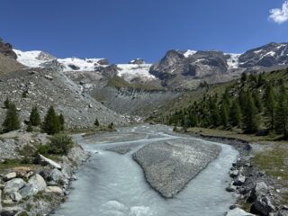 Si vedono i Breithorn, Roccia Nera, Polluce e Castore.
Il rifugio rimane dietro in alto dopo la morena.